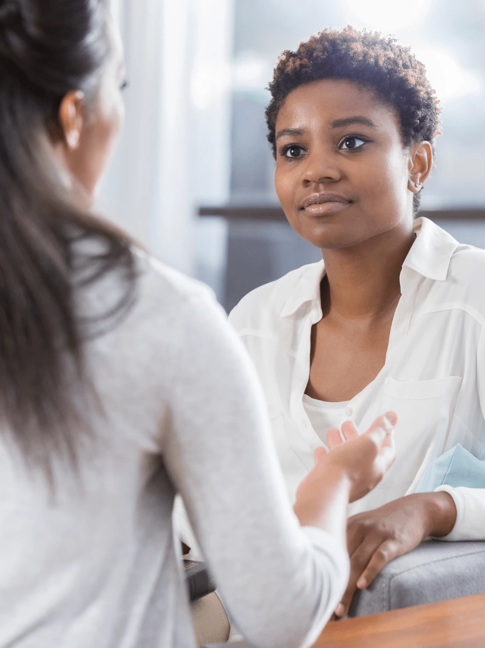A counselor listening compassionately to a client during a therapy session